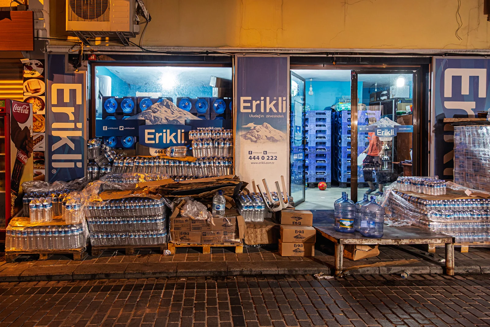 A brightly lit street kiosk at night.