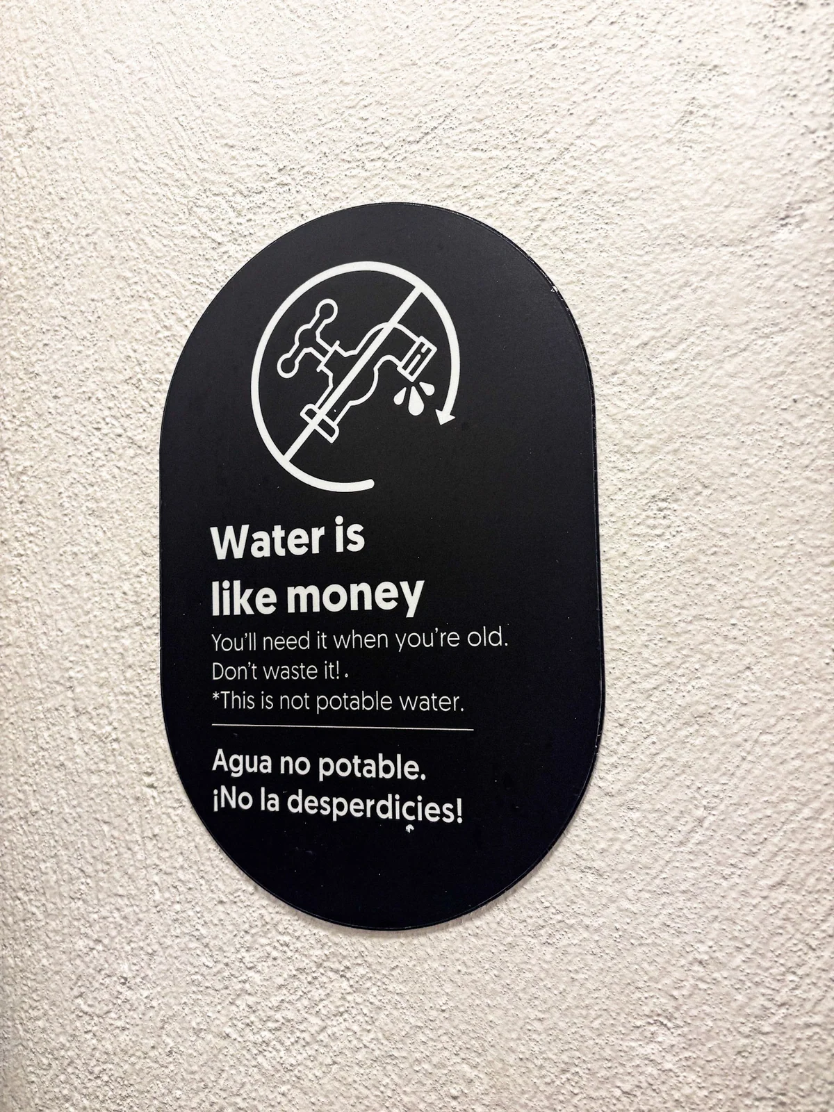 A small water conservation sign on a wall.