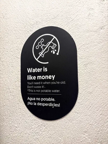 A small water conservation sign on a wall.