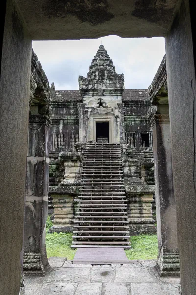 A temple tower and staircase framed by a dark stone doorway.