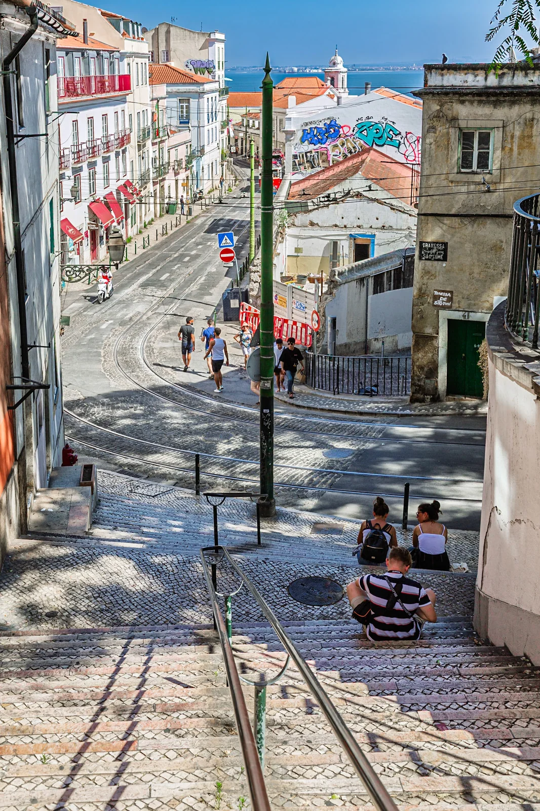 Tram tracks descending through a street between tall buildings.