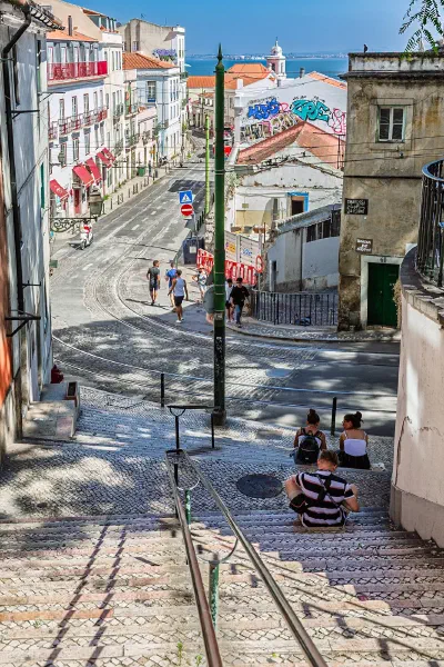 Tram tracks descending through a street between tall buildings.