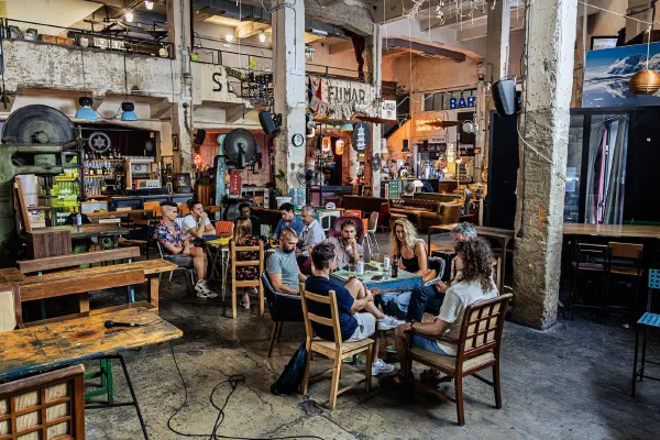 An audience gathered for a talk inside the industrial interior of Talleres Palermo.