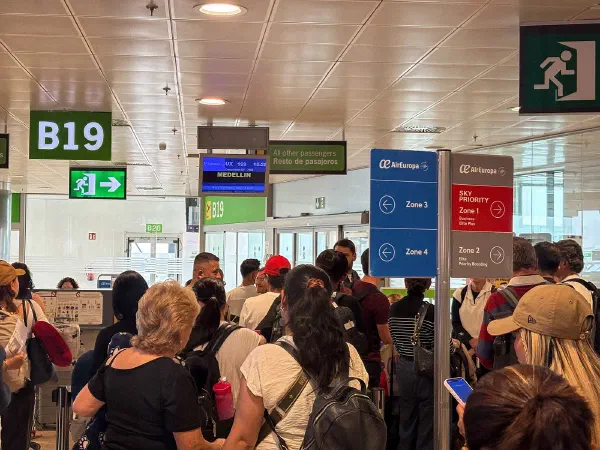 Travellers queuing at an airport gate.