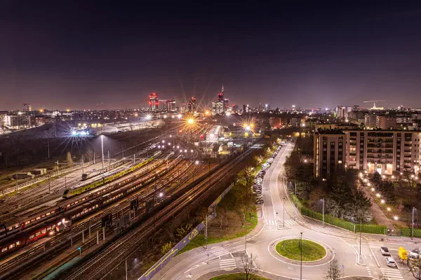 A railway yard and roundabout lit up at night.